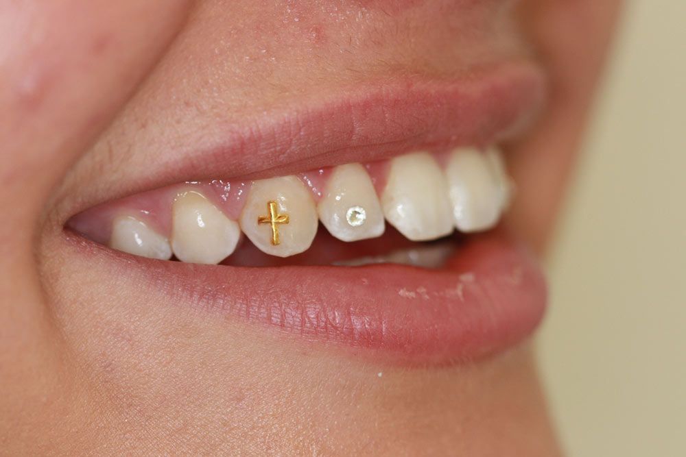 Et tandsmykke udformet som et kors
